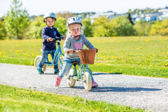 Kinder auf einem Lauflernrad
